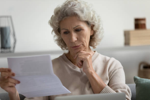 istock Focused mature 60s retired lady receiving letter 1310961964