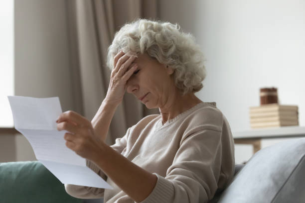 istock Upset elderly woman sitting on couch at home 1310961966