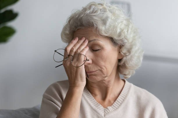 istock Tired senior lady holding glasses and rubbing face 1310961979