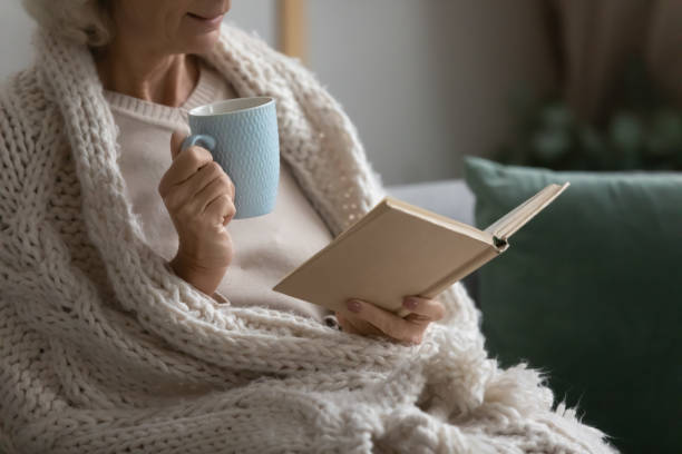 istock Old retired 70s lady reading book at home 1310961990