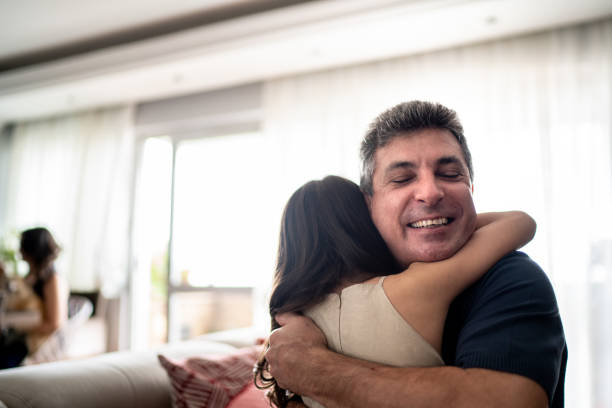 istock Daughter embracing father at home 1310962110