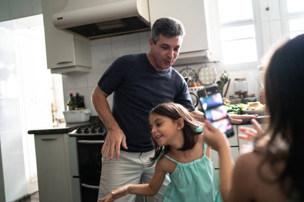 Girl filming father and daughter dancing at home Girl filming father and daughter dancing at home happy fathers day funny stock pictures, royalty-free photos & images