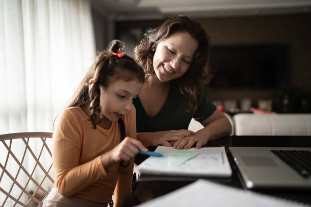 istock Mother helping daughter during homeschooling 1310962549