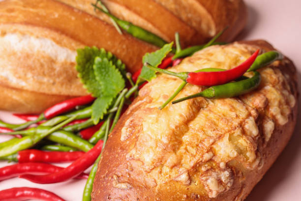 Fresh bread on the table with red and green chili peppers.