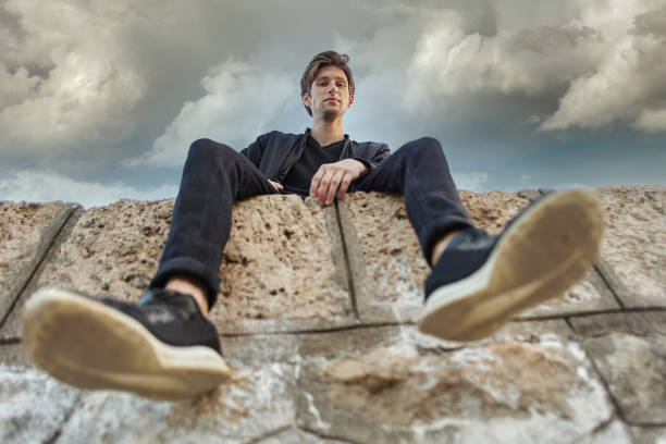 istock Young Caucasian man sits on pier in Antalya, bottom view. 1310966449