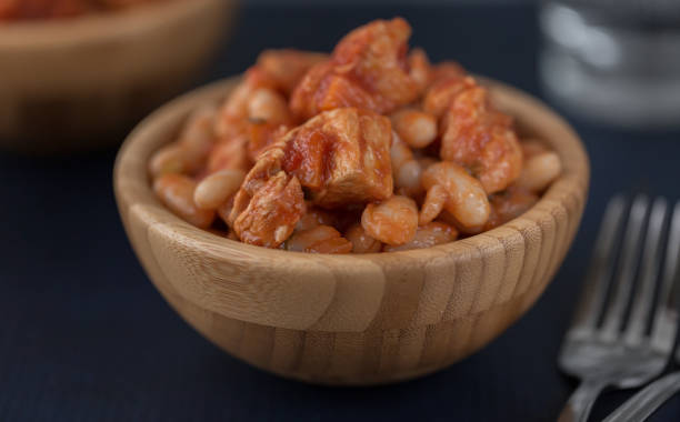 istock Pork stew with white beans in a wooden bowl. 1310966738