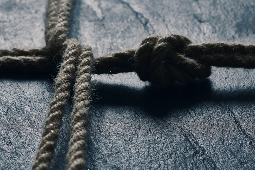 Rope with a tied knot lying on stone surface
