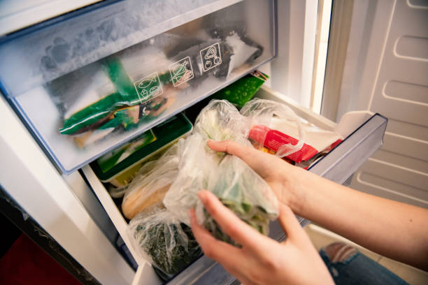 girl taking raw food from refrigerator - people cold frozen unrecognizable person imagens e fotografias de stock