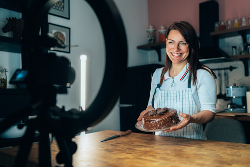 Woman vlogger recording video for food channel baking cake