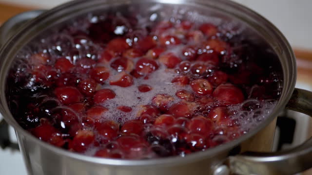 Cooking Vitamin Compote from Frozen Cherries, Blackberries in Home Kitchen