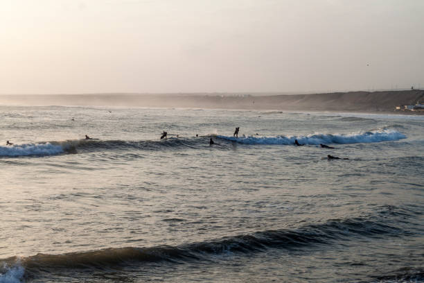 huanchaco, peru - 6 июня 2015 г.: люди занимаются серфингом в волнах океана в уанчако, перу. - huanchaco стоковые фото и изображения