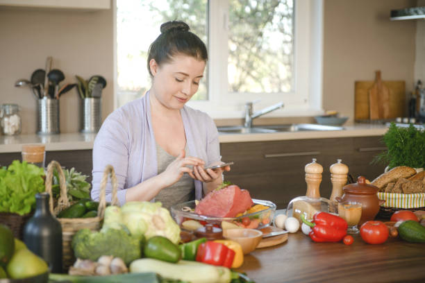 istock woman cooking in the kitchen ( beef and smart phone) 1310975100