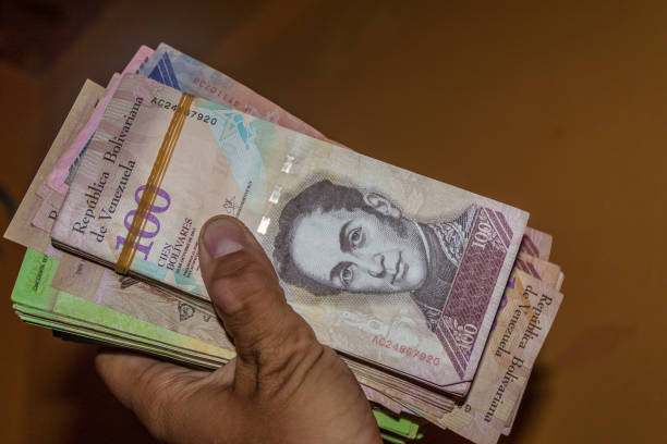 istock Stack of Venezuelan currency (Bolivar Fuerte) is hold in the hand. Due to hyperinflation, it is necessary to use thick stack of bills to cover basic needs. 1310975330