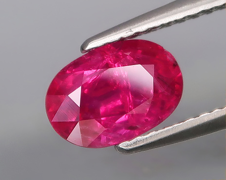 Natural gemstone red ruby on a gray background