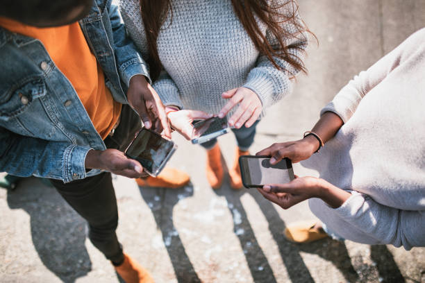 Group of Young Adult Friends On Smartphones stock photo