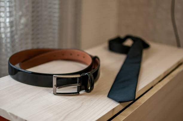 istock Black mans belt and tie on the table 1310977271