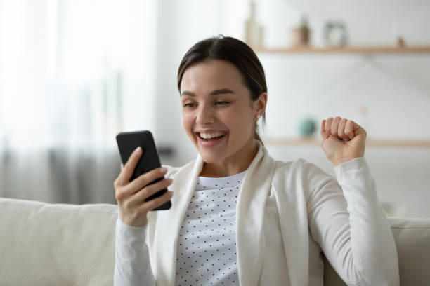 istock Close up overjoyed young woman looking at phone screen 1310977296