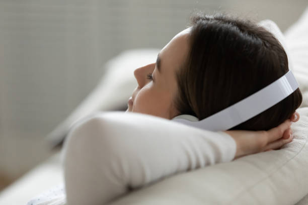 istock Close up peaceful relaxed young woman wearing headset enjoying music 1310977310
