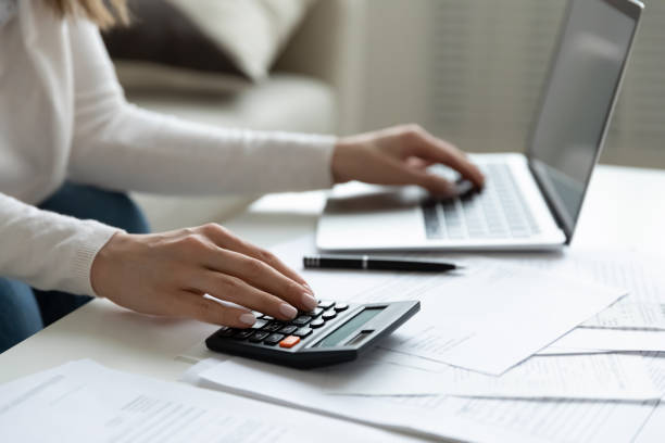 istock Close up young woman using calculator and laptop, checking bills 1310977314