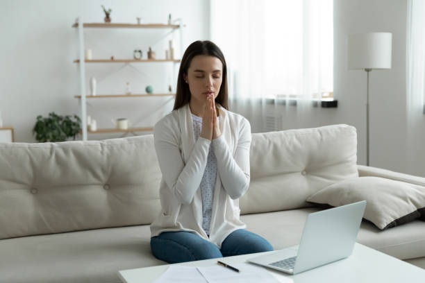 istock Calm young woman joining hands in prayer, asking help 1310977356