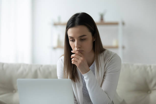 istock Serious thoughtful young woman using laptop at home 1310977364