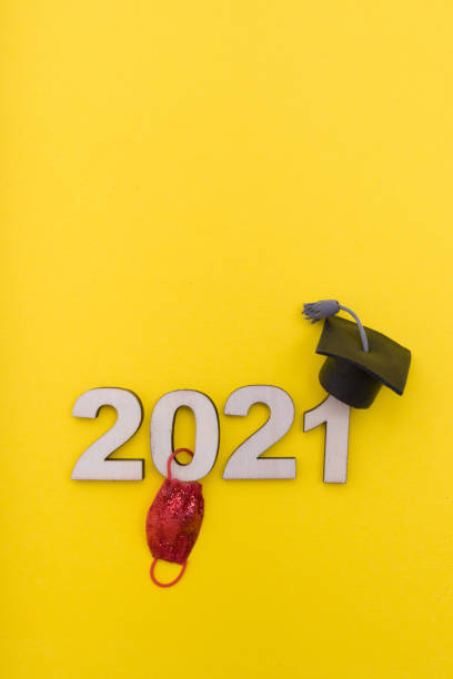 formatura durante coronavírus 2021: número de madeira 2021 em chapéu de formatura com máscara médica no fundo amarelo. - junior high fotos - fotografias e filmes do acervo