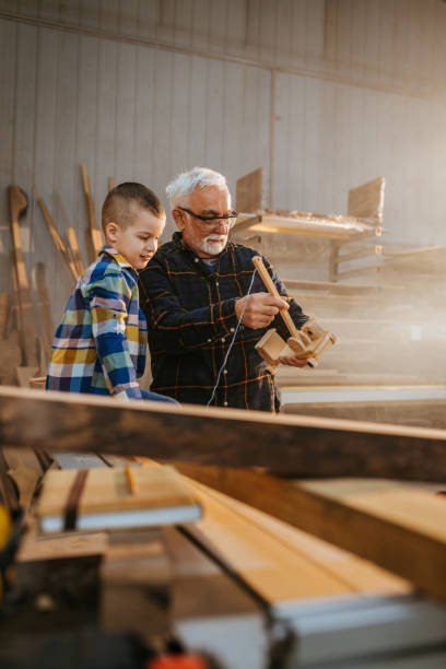 istock Boy with grandpa at carpenter workshop 1310978680