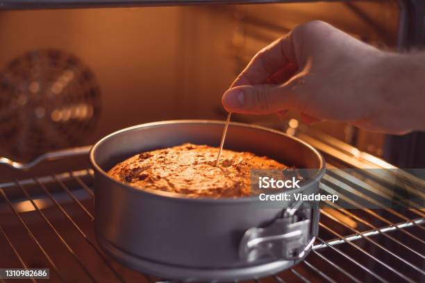 Check A Cake For Doneness By Using The Toothpick Test Stock Photo - Download Image Now