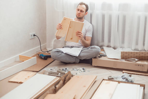 istock Man assembling the furniture. Comparing two similar details 1310982747