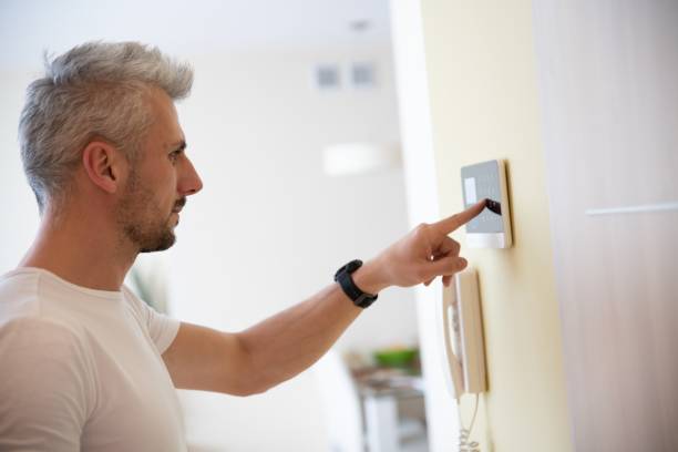 istock A man presses buttons on the control panel to disarm the burglar alarm system. 1310983044