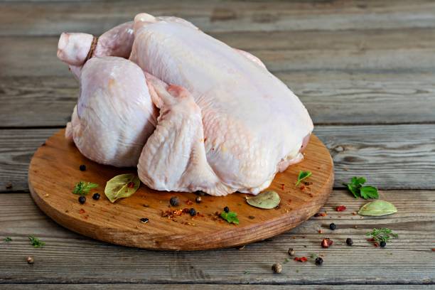 istock Raw chicken carcass ready for cooking on a cutting board on wooden background. 1310983864