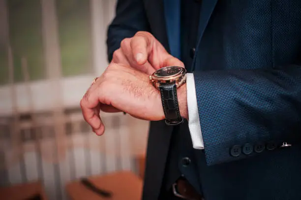 Photo of Man in the room fastening wristwatch on the arm