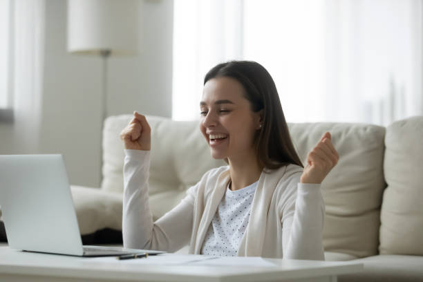 istock Overjoyed young woman looking at laptop screen, celebrating success 1310986421