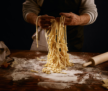 Image of a chef pulling the freshly made pasta