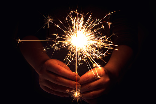 The woman who lights the dark with a sparkler in her hand.