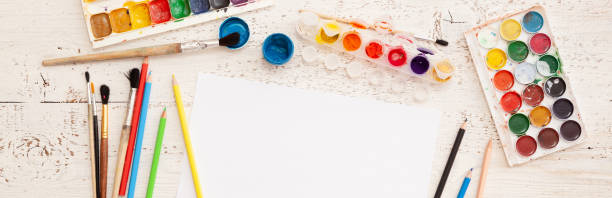 istock A creative space for drawing and embodying creative ideas. Creativity and early learning. Education concept. Top view of watercolors, brushes and some artistic things on white background. Wide view 1310987260