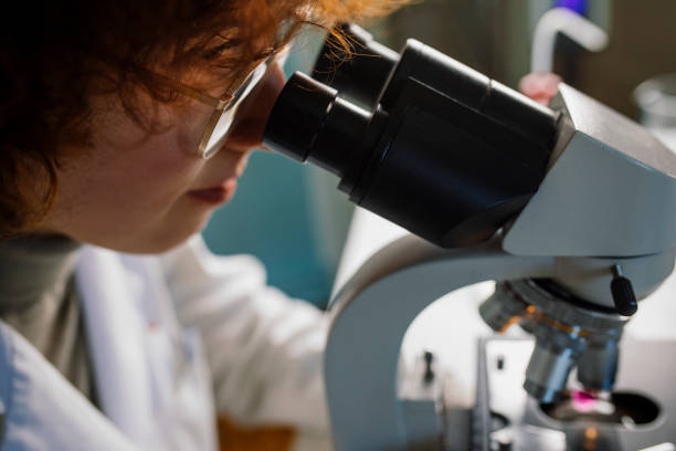 istock Young Medical Researcher Looking through a Microscope at a Hospital Laboratory 1310989316
