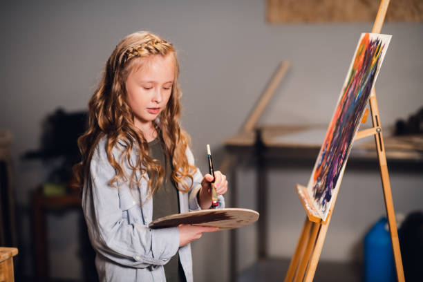 istock An art school student mixes colors on a palette for her canvas drawing in a workshop 1310990874