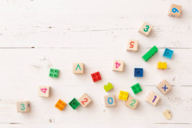 istock Developing multi-colored cubes on a white wooden table. Wooden cubes with numbers 2021 and others. Top view of the numbers of the year and other educational toys. 1310993621
