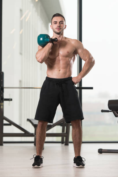 hombre musculoso haciendo ejercicio con campana de hervidor de agua - kettle bell activity aerobics athlete fotografías e imágenes de stock
