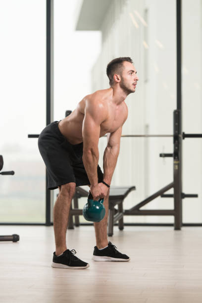 hombre haciendo ejercicio con campana de hervidor de agua - kettle bell activity aerobics athlete fotografías e imágenes de stock