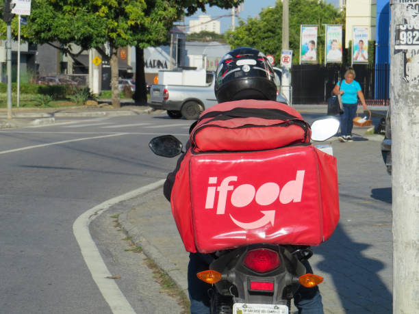 el motociclista ifood entrega comida a los clientes de la ciudad durante la pandemia covid-19. ifood. - editorial crowd driver people fotografías e imágenes de stock