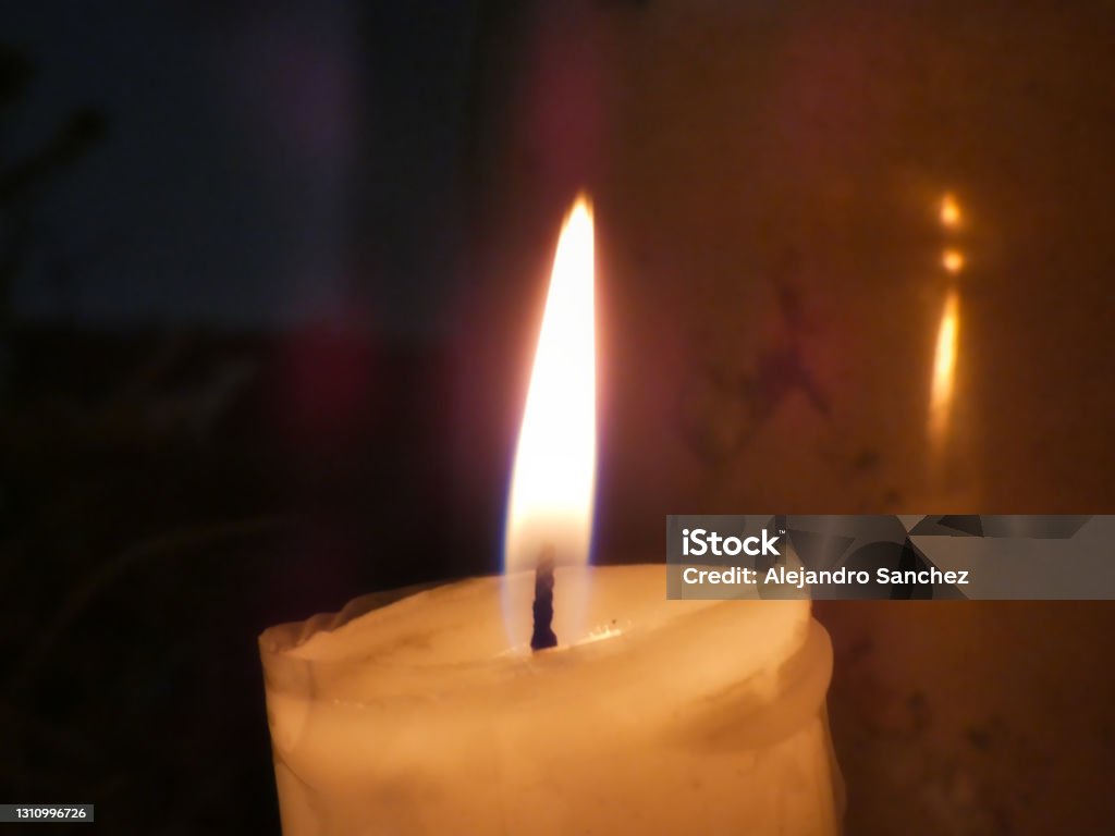 Candle in front of a vessel Soft light of a candle in front of a vessel and with a dark background. Burning Stock Photo