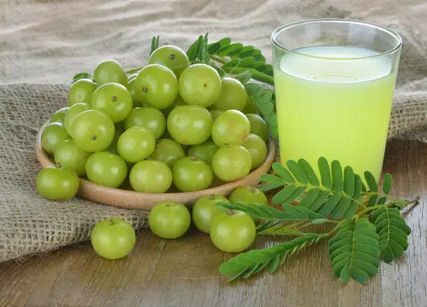 Indian gooseberry juice on the wooden floor