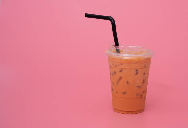 istock Plastic cup of ice milk tea on pink background 1310998651
