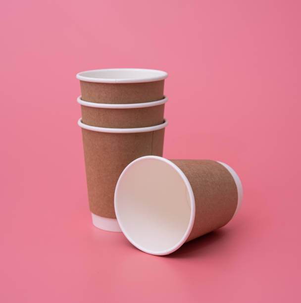 istock Craft cup paper. Blank brown coffee cup on pink background 1310998665