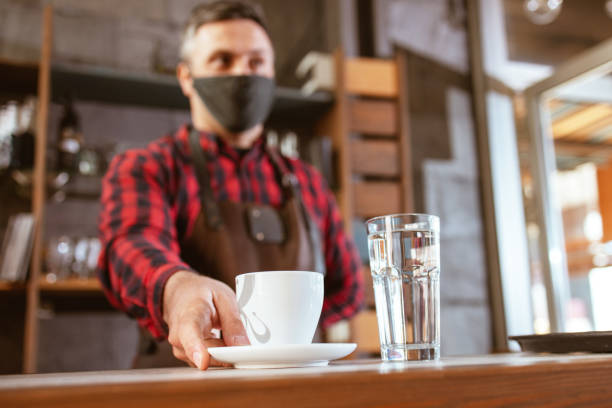 istock Barista working with protective face mask in coffee shop 1311001023