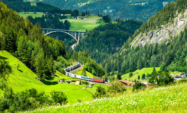 trein met aanhangwagens die de alpen in oostenrijk kruisen - brennerpas stockfoto's en -beelden