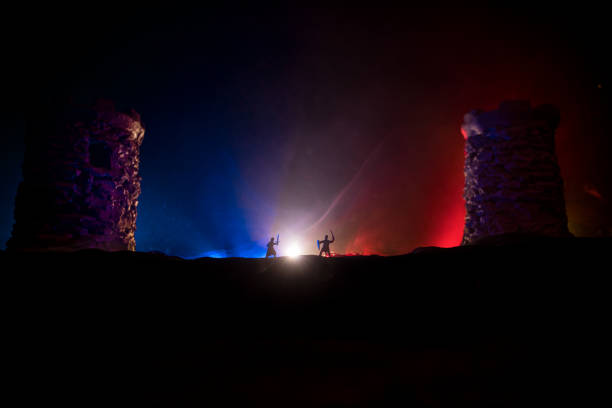 istock Medieval battle scene. Silhouettes of figures as separate objects, fight between warriors at night. Creative artwork decoration. Foggy background. 1311008766