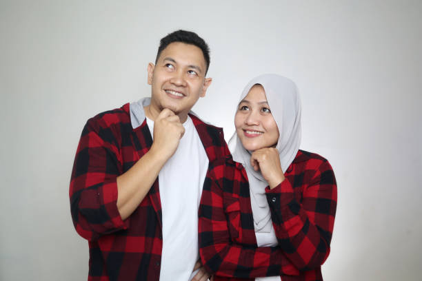 Happy Asian Muslim Couple Dreaming Portait of happy Asian muslim couple smiling, looking up and dreaming, husband and wife hugging full of love, family concept happy malay couple stock pictures, royalty-free photos & images